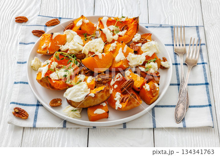 baked butternut squash with cheese, thyme, pecan baked butternut squash with cheese, thyme, pecan 134341763