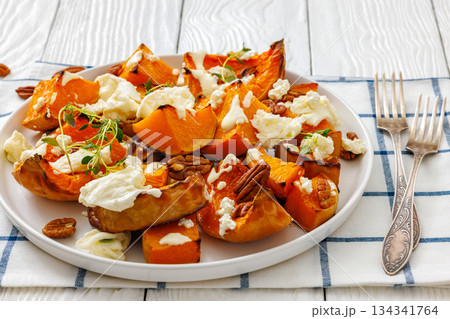 baked butternut squash with cheese, thyme, pecan 134341764