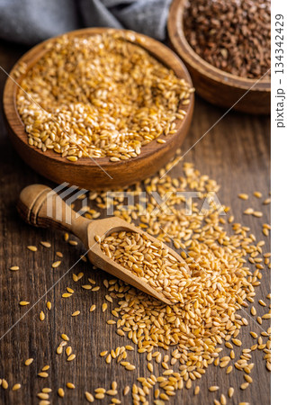 Golden linseed or flaxseed. Healthy flax seed on scoop on wooden table. Golden linseed or flaxseed. Healthy flax seed on scoop on wooden table. 134342429