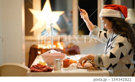Young lady with Santa hat and illuminated star on festive evening 134342822
