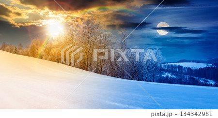 panorama of a beautiful landscape on winter solstice. day and night time change concept. forest on a snow covered meadow with sun and moon at twilight. duality and transition template 134342981