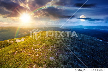 grassy slopes with boulders of mountain. day and night time change concept. beautiful summer solstice scenery in alpine green environment under sky with sun and moon. harmony and progress calendar grassy slopes with boulders of mountain. day and night time change concept. beautiful summer solstice scenery in alpine green environment under sky with sun and moon. harmony and progress calendar 134343026