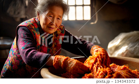 Middle-aged Woman Preparing Traditional Korean Kimchi in a Rustic Kitchen Setting for Authentic Cultural Experience 134343372