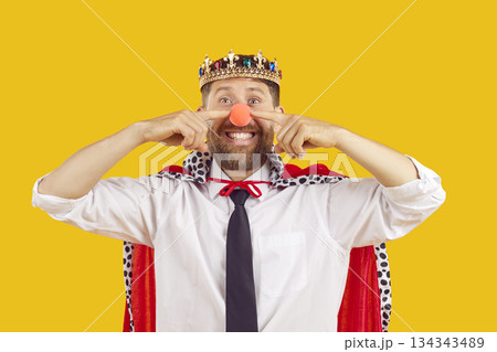 Happy funny office worker in costume of king and clown at corporate fancy dress party 134343489