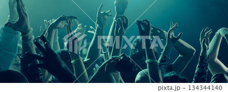 Raised hands moving to music under soft festive lighting. Banner Raised hands moving to music under soft festive lighting. Banner 134344140