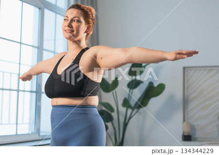 Fitness workout training. Woman practicing fitness at home. Plus size female doing sports exercise at home indoor. Girl in sportswear have workout weight training for weight loss. Sport and fitness Fitness workout training. Woman practicing fitness at home. Plus size female doing sports exercise at home indoor. Girl in sportswear have workout weight training for weight loss. Sport and fitness 134344229