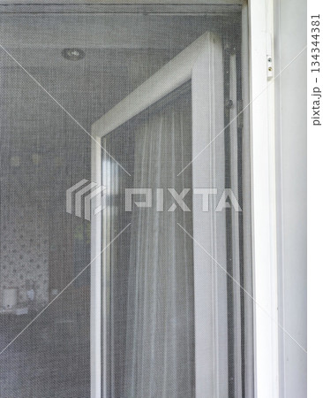 Mosquito window screen and open PVC window home ventilation close up vertical Mosquito window screen and open PVC window home ventilation close up vertical 134344381