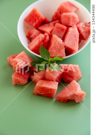 watermelon cubes on green background with natural texture 134344490