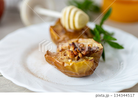 Traditional autumn dessert of apples filled with honey and nuts 134344517