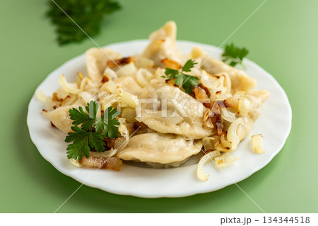 Rustic dumplings with caramelized onions and fresh parsley garnish Rustic dumplings with caramelized onions and fresh parsley garnish 134344518