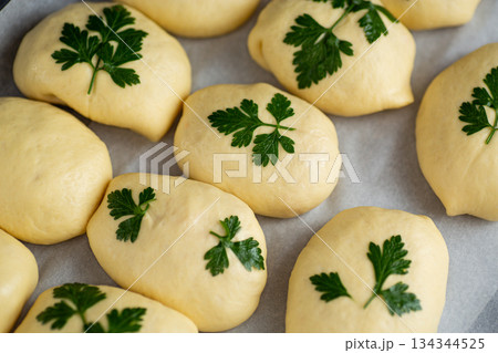 Unbaked dough pieces decorated with parsley ready for oven 134344525