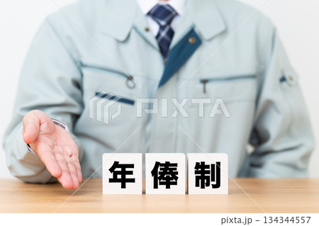 年俸制のブロックと作業着を着たミドル男性ビジネスマン 134344557