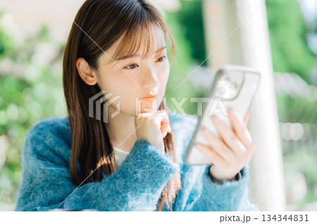 テラスでスマホを見る女性 134344831