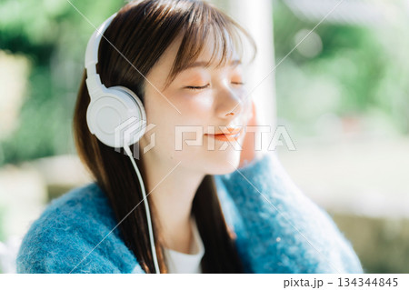 テラスで音楽を聴く若い女性 テラスで音楽を聴く若い女性 134344845