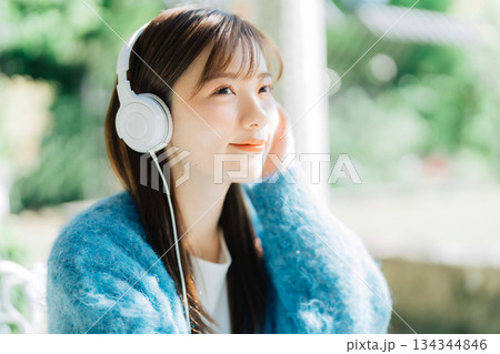 テラスで音楽を聴く若い女性 134344846