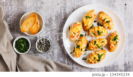 Baked sandwiches with crab salad and greens on a plate on the table top view web banner 134345234