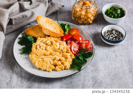 Vegetarian chickpea puree with vegetables on a plate on the table 134345238