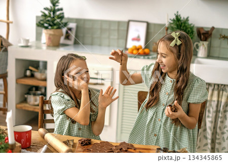 Children play with ginger cookie dough in the kitchen. Making holiday cookies for Christmas and New Year. 134345865