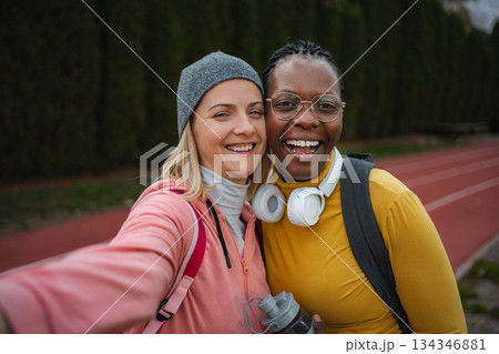 Happy diverse women friends taking selfie on running track 134346881