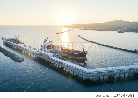 Aerial view of a large oil tanker docked at a pier in the port in process of loading. 134347081