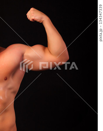 Strong arm of an athlete, isolated on black background Strong arm of an athlete, isolated on black background 134347339