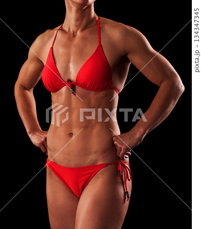 Muscular female body against black background. Muscular female body against black background. 134347345