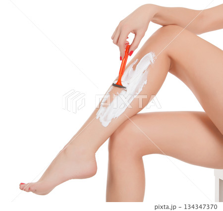 Woman shaving her legs, isolated on white background Woman shaving her legs, isolated on white background 134347370