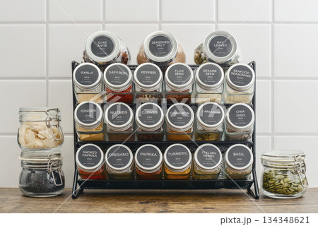 Assorted spices in glass jars with metal lids 134348621