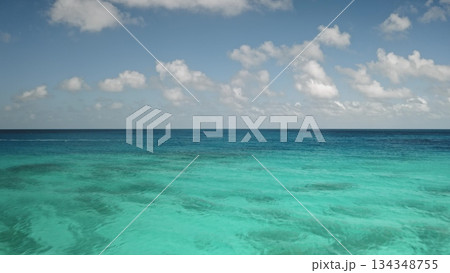 French Polynesia, Rangiroa island: stunning view of crystal clear turquoise ocean water and vast blue sky with fluffy white clouds. Breathtaking panorama of wild nature beauty. Drone flight 134348755
