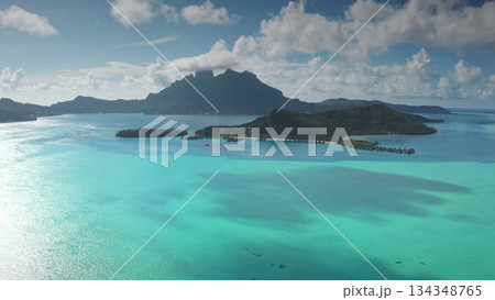 Captivating aerial view of Bora Bora, showcasing mount Otemanu, a crystal-clear turquoise lagoon, and luxurious overwater bungalows in a tropical paradise 134348765
