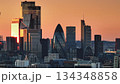 United Kingdom, London: Illuminating warm sunset colors over London's modern cityscape, highlighting iconic skyscrapers like the Gherkin in a stunning panorama. Drone flight United Kingdom, London: Illuminating warm sunset colors over London's modern cityscape, highlighting iconic skyscrapers like the Gherkin in a stunning panorama. Drone flight 134348858