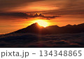 Bali, Mount Batur volcano silhouette rising above a layer of soft clouds during a vibrant golden and orange sunset, creating a serene and breathtaking natural landscape. Aerial view panorama Bali, Mount Batur volcano silhouette rising above a layer of soft clouds during a vibrant golden and orange sunset, creating a serene and breathtaking natural landscape. Aerial view panorama 134348865