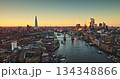 England, aerial London skyline at sunset with iconic landmarks Tower Bridge, The Shard skyscraper, and illuminated buildings of Canary Wharf on River Thames. Modern cityscape under bright evening sky England, aerial London skyline at sunset with iconic landmarks Tower Bridge, The Shard skyscraper, and illuminated buildings of Canary Wharf on River Thames. Modern cityscape under bright evening sky 134348866