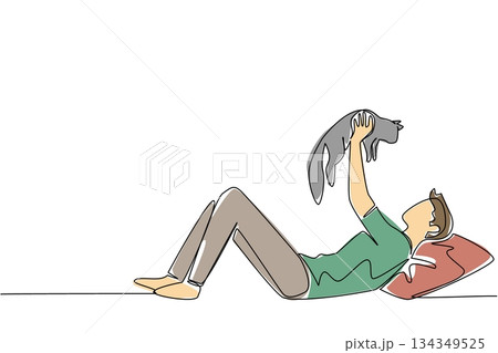 Single continuous line drawing a man in casual clothes lying down lifting and hugging a cat. Adorable game with pet cat. Cheerful. International Hug Your Cat Day. One line design vector illustration 134349525