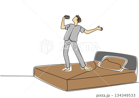 Continuous one line drawing a man in casual clothes wear headphone stand on a bed hold a smartphone used as a mic. Hobby. Music. National Sing Out Day. Single line draw design vector illustration 134349533