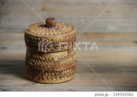 a handcrafted birch bark container featuring intricate carved patterns a handcrafted birch bark container featuring intricate carved patterns 134350382