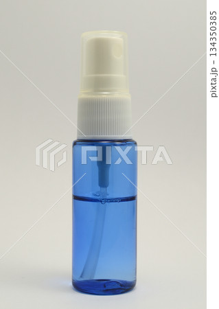 a small transparent spray bottle filled with blue liquid a small transparent spray bottle filled with blue liquid 134350385