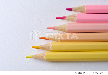 Close-up of six sharp-tipped colored pencils arranged horizontally with color gradation from hot pink to light yellow, white background Close-up of six sharp-tipped colored pencils arranged horizontally with color gradation from hot pink to light yellow, white background 134351248