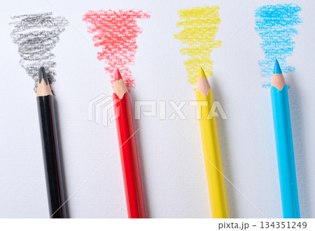 Four colored pencils lie diagonally on white paper, with a stroke of the corresponding color next to each pencil Four colored pencils lie diagonally on white paper, with a stroke of the corresponding color next to each pencil 134351249