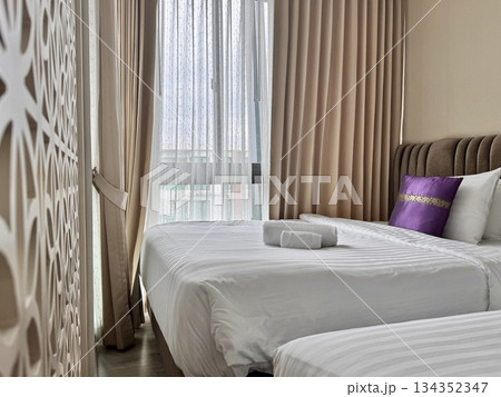 There is a double bed in the hotel room with neatly made bed linen and towels. High quality photo 134352347