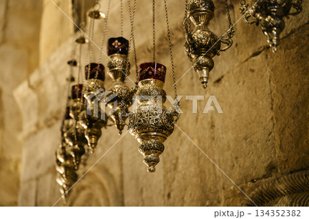 Intricate Antique Orthodox Oil Lamps Hanging in Stone Church 134352382