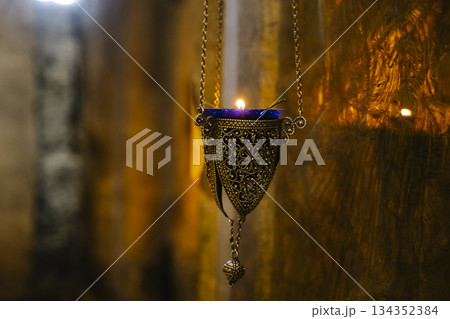 Intricate Antique Orthodox Oil Lamps Hanging in Stone Church 134352384