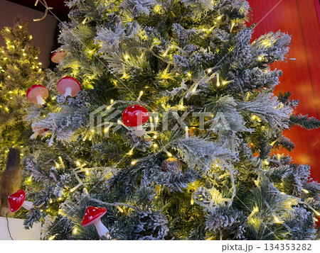 Christmas tree decorated with mushroom ornaments and warm lights indoors. Whimsical holiday design, fairy tale decoration, playful tradition, cozy winter atmosphere and creative Christmas styling Christmas tree decorated with mushroom ornaments and warm lights indoors. Whimsical holiday design, fairy tale decoration, playful tradition, cozy winter atmosphere and creative Christmas styling 134353282