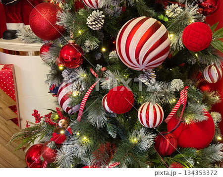 Red and white Christmas ornaments on decorated fir tree. Holiday atmosphere, festive tradition, winter celebration and cozy seasonal decor. Red and white Christmas ornaments on decorated fir tree. Holiday atmosphere, festive tradition, winter celebration and cozy seasonal decor. 134353372