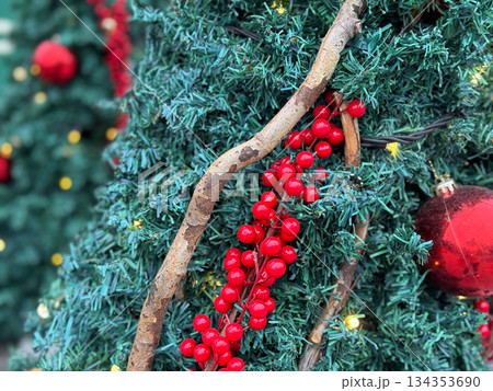Close-up of Christmas tree branch with red berries and ornaments. Festive seasonal decor, winter celebration and traditional holiday styling. Close-up of Christmas tree branch with red berries and ornaments. Festive seasonal decor, winter celebration and traditional holiday styling. 134353690