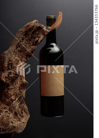 Bottle of red wine with empty label on a old wooden snag. 134353766