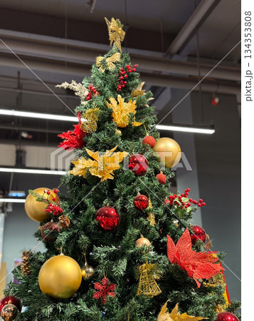 Christmas tree decorated with red and gold ornaments indoors. Festive seasonal decor, traditional holiday styling, cozy winter atmosphere and classic festive design 134353808