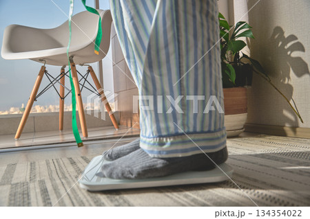 Person standing on scale for new year resolutions Person standing on scale for new year resolutions 134354022