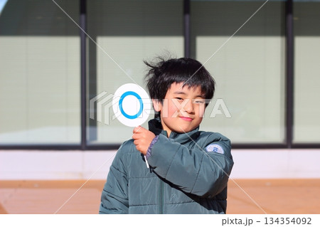 まる札を持つ男の子 134354092