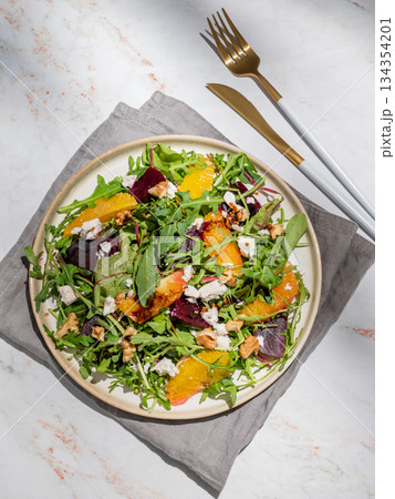 A fresh salad of beets, orange, and arugula with feta, walnuts, and balsamic dressing on a plate A fresh salad of beets, orange, and arugula with feta, walnuts, and balsamic dressing on a plate 134354201